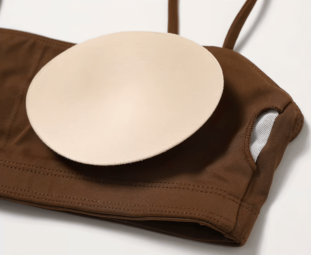 Close-up of brown shockproof yoga sports bra with removable padding, showcasing breathable design and snug fit for fitness activities.