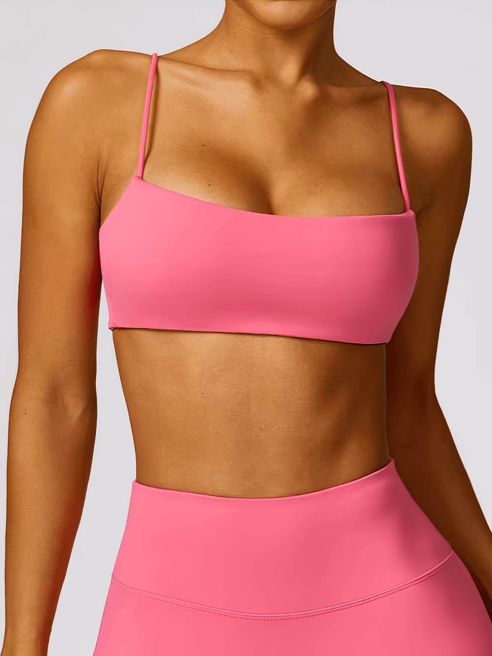Woman wearing a pink shockproof yoga sports bra, perfect for gym, fitness, and yoga with breathable, quick-dry technology.