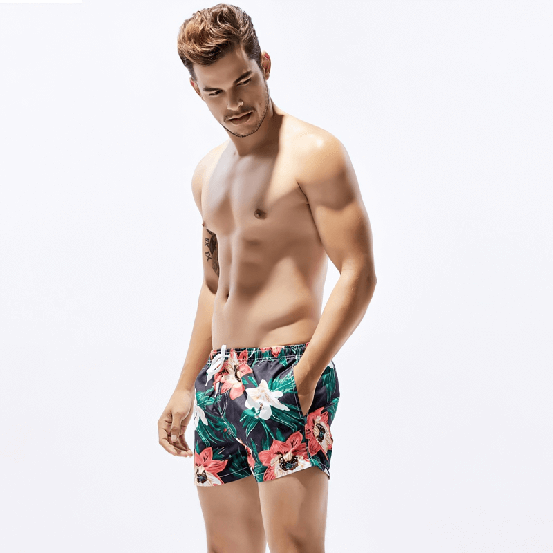 Vibrant floral men's boardshorts perfect for a stylish beach day, featuring quick-dry polyester and a secure fit for comfort and style.