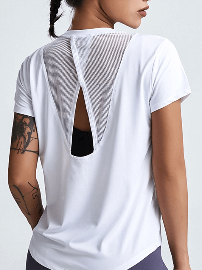 Woman wearing short-sleeved running T-shirt with hollow back for yoga; breathable, quick-dry, anti-wrinkle fabric.