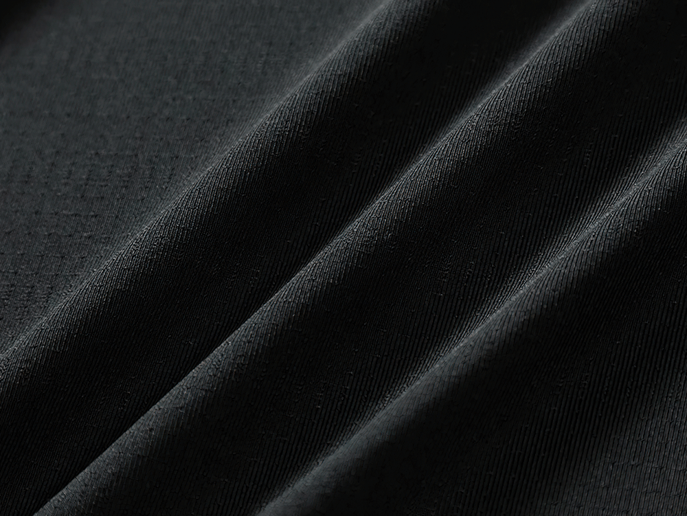 Close-up of black polyester-spandex fabric with subtle texture, highlighting the breathable material of the men's fitness t-shirt.