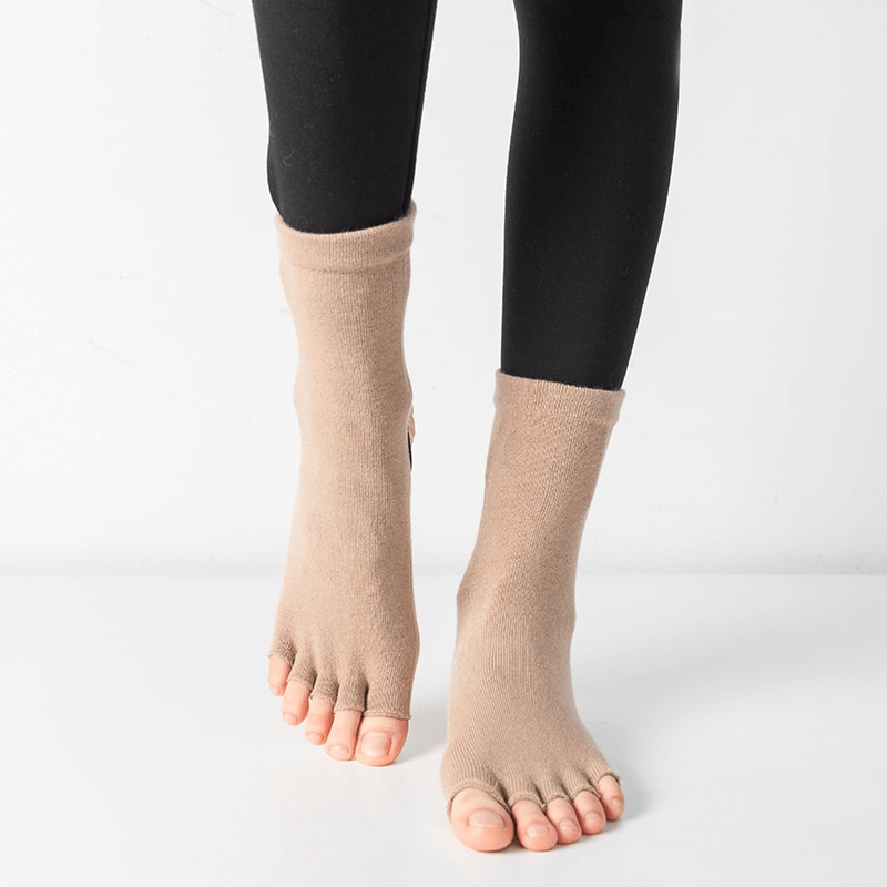 Beige toeless Pilates socks with non-slip grips worn for yoga and dance.