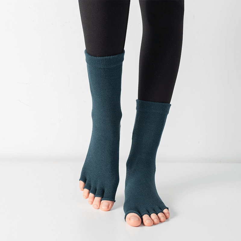 Model wearing silicone non-slip toeless Pilates socks in deep blue, featuring a five-finger design for yoga and fitness balance.