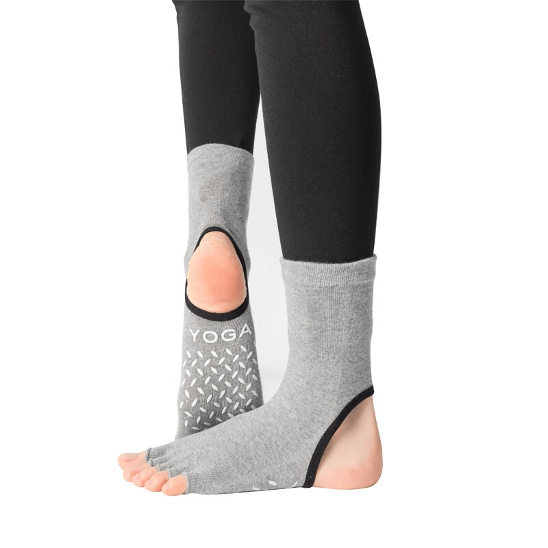 Gray silicone non-slip toeless Pilates socks for yoga with five-finger design providing grip and balance.