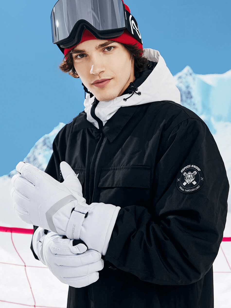 Person wearing unisex black ski gloves with holder wristbands, ready for winter sports on a snowy mountain background.