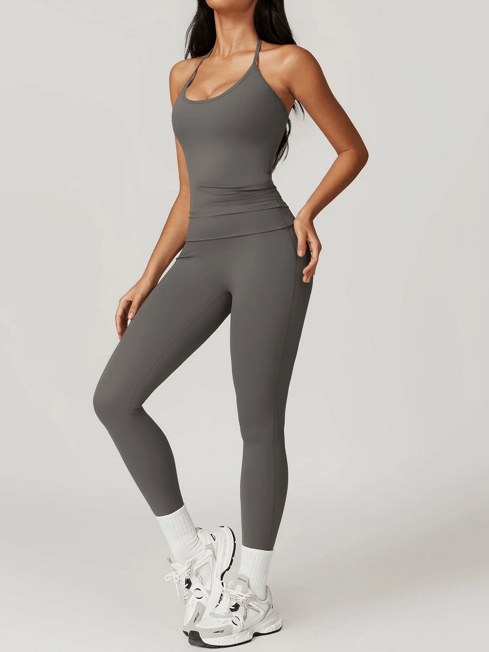 Woman wearing Sleek Halter Neck Sports Tank SF2446 for yoga and training in grey, showing style and support with breathable fabric.