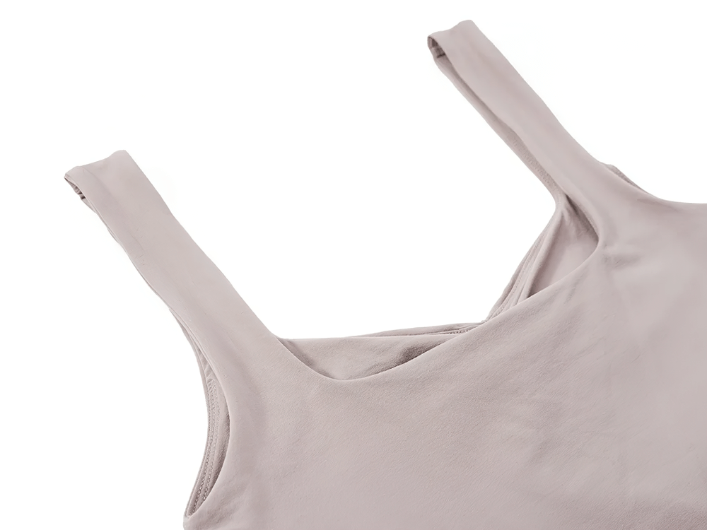 Close-up of sleek ruched square-neck tank top in soft fabric, showcasing wide supportive straps and elegant design.