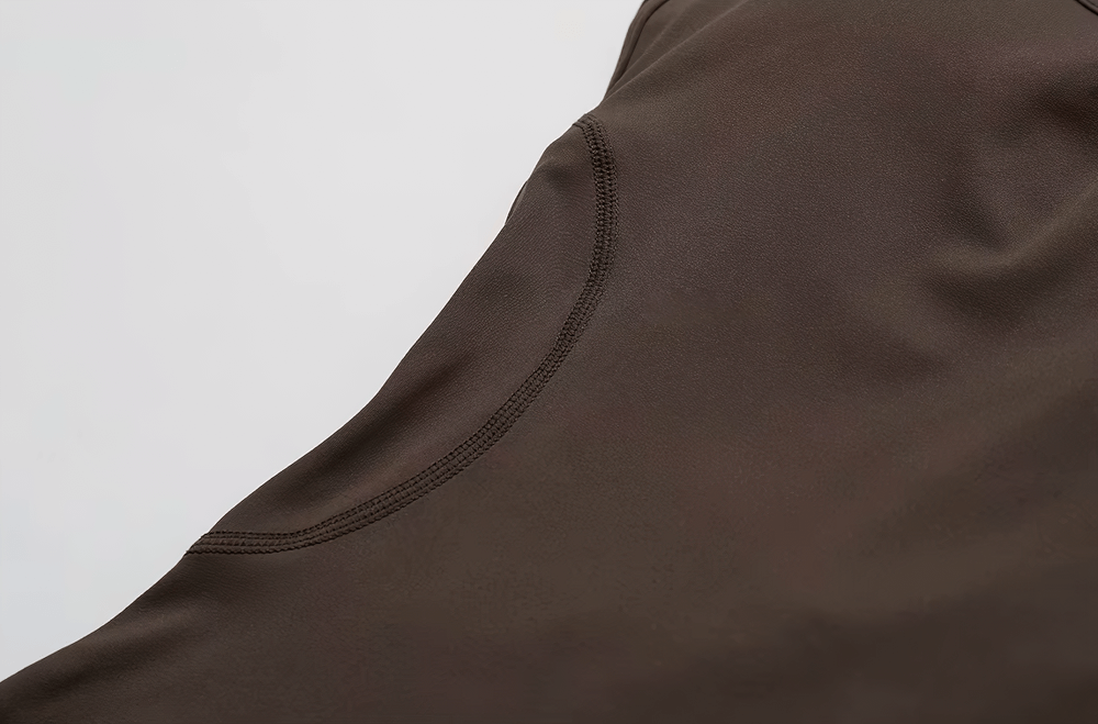 Close-up of brown fabric showcasing the texture and stitching of a yoga jumpsuit.