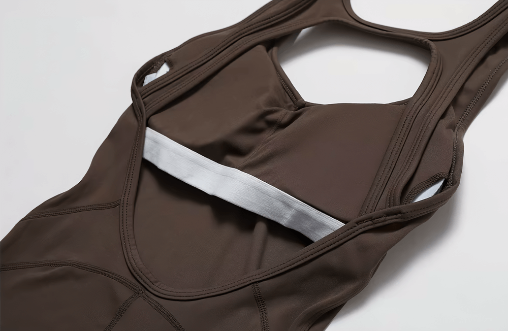 Close-up of a brown sleeveless backless yoga jumpsuit for women, showcasing stitching and material detail.