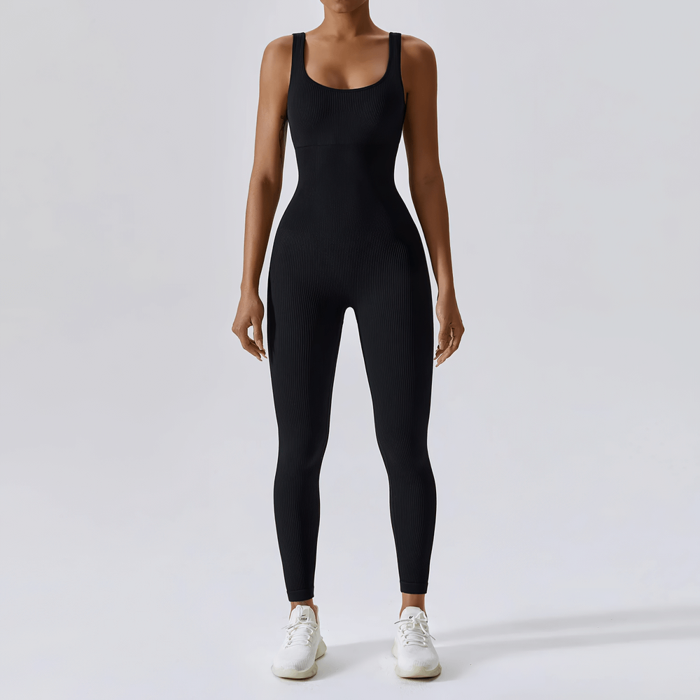 Woman wearing a black sleeveless seamless one-piece yoga suit, perfect for running, hiking, and dancing, showcasing a sleek athletic look.