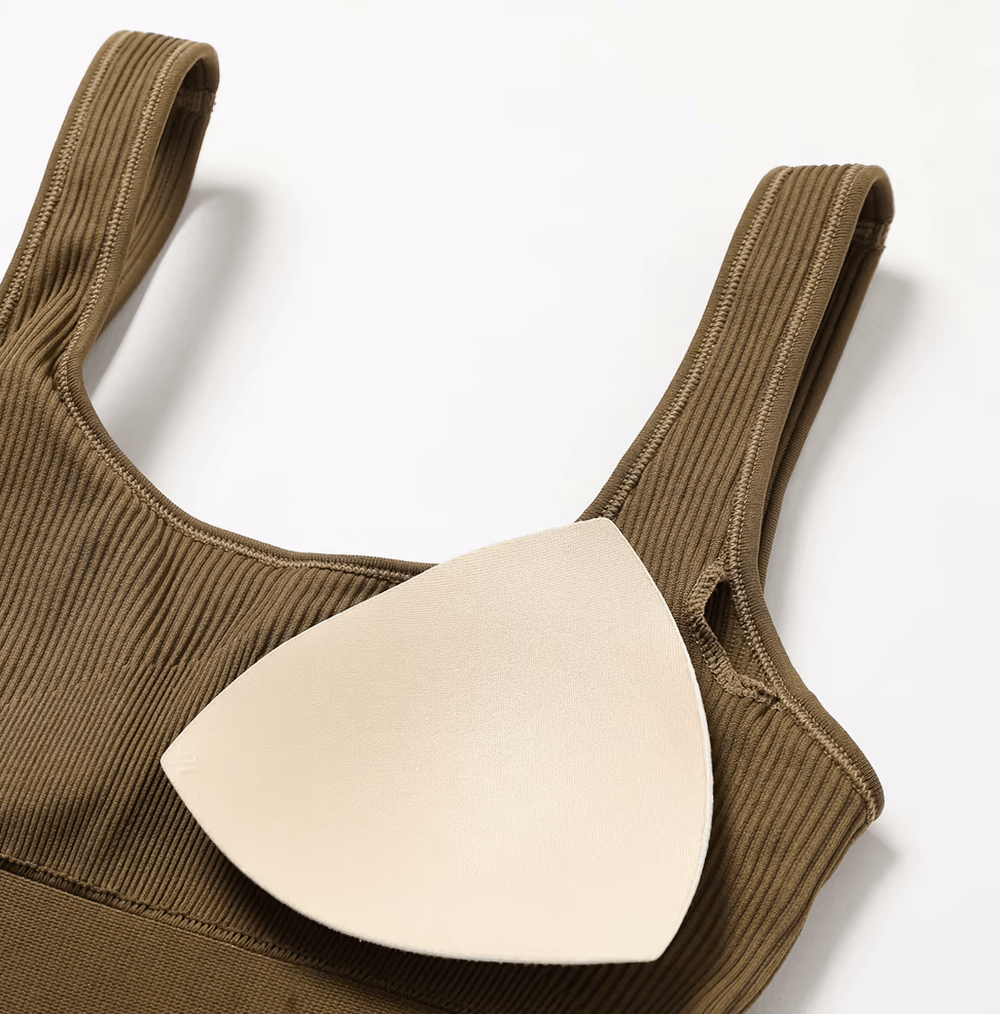 Close-up of a brown sleeveless seamless one-piece yoga suit with a removable padded insert, crafted from breathable, quick-dry fabric.