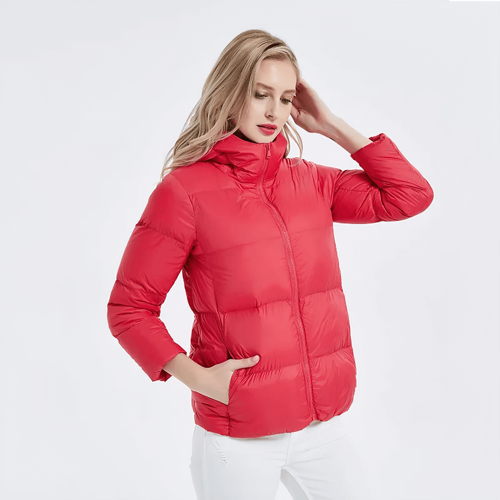 Woman wearing a red slim fit duck down jacket with a hood and pockets, perfect for warmth and style on chilly days.