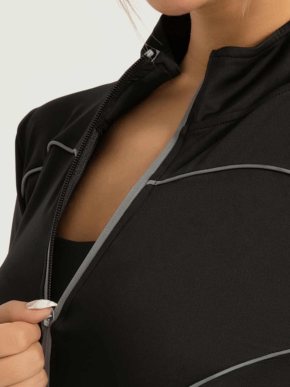 Close-up of black slim fit sports jacket with reflective detailing and full zip, featuring thumb holes for running and workouts, style SF2569.