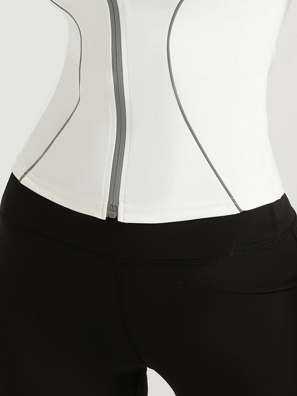 Close-up of women's slim fit sports jacket with full zip and thumb holes, featuring reflective details, ideal for workouts and running.