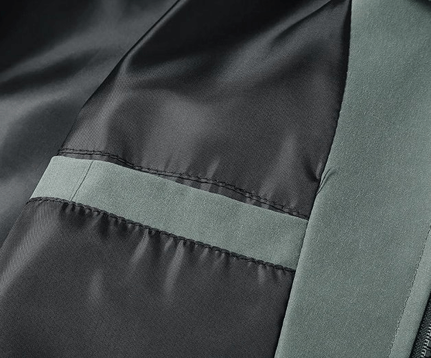 Close-up of slim men's sporty jacket, showcasing big pocket and zipper in stylish black polyester fabric, SF1969 model.