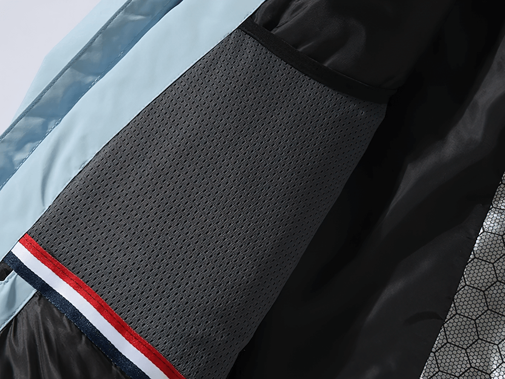 Close-up of waterproof snowboard jacket fabric with textured design and multiple color accents for winter sports.