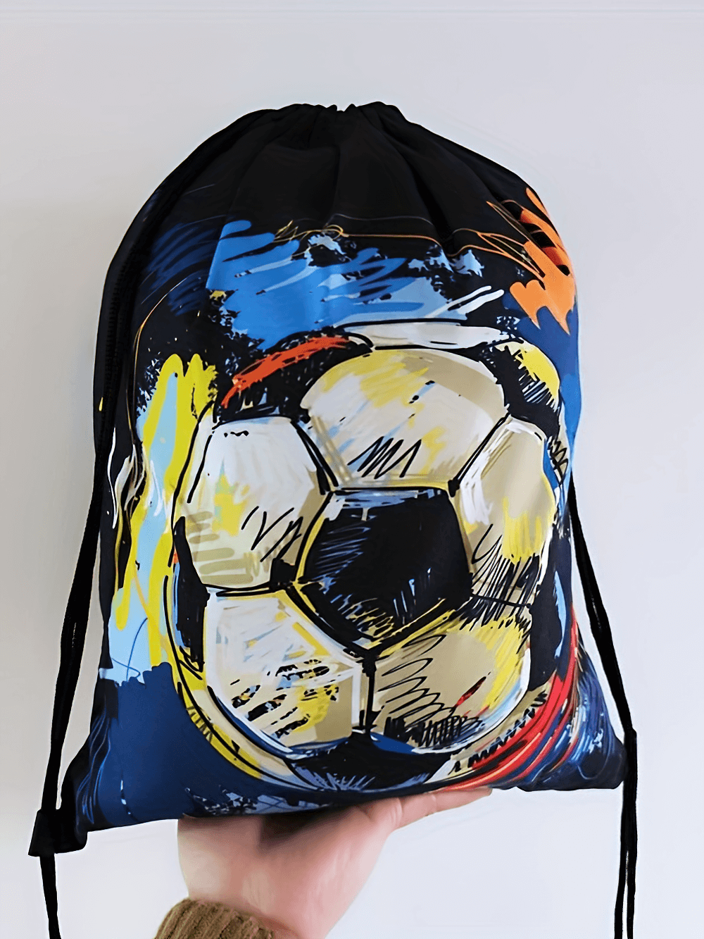 Vibrant soccer ball design drawstring backpack, lightweight polyester gym bag with adjustable straps, perfect for sports and travel.