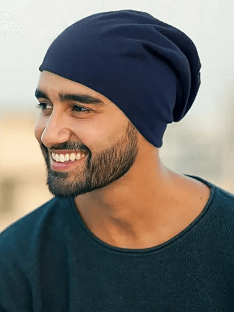 Smiling person wearing a soft lightweight running beanie, unisex design in solid color, perfect for casual and athletic wear.