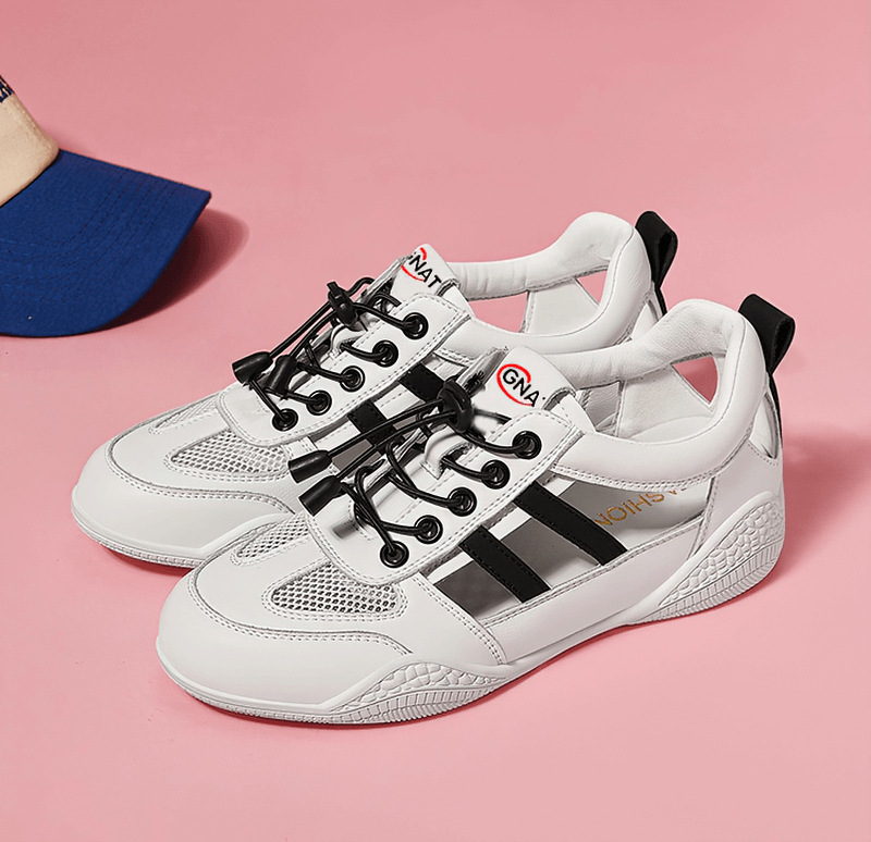 White and black lace-up casual running shoes on a pink background.