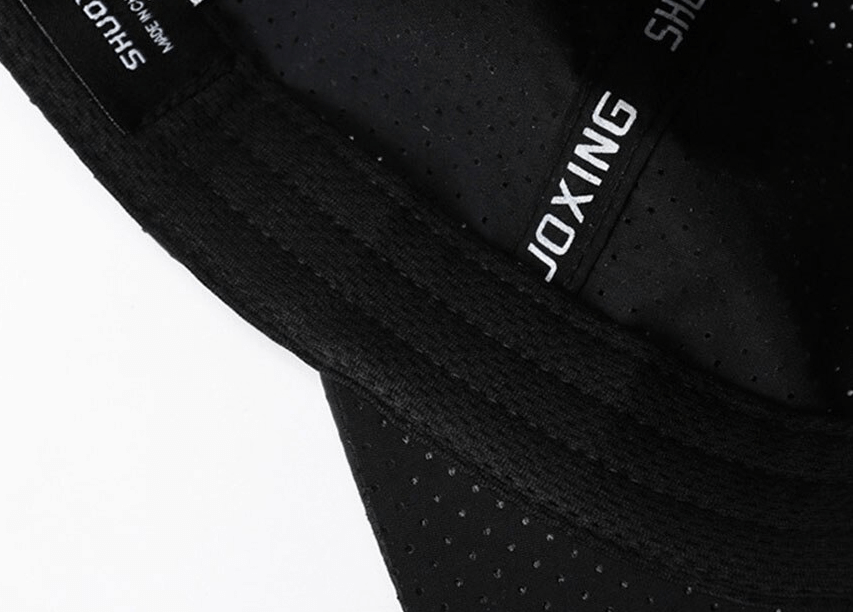Close-up of black breathable mesh fabric on an outdoor sports baseball cap with visible stitching and logo accents.