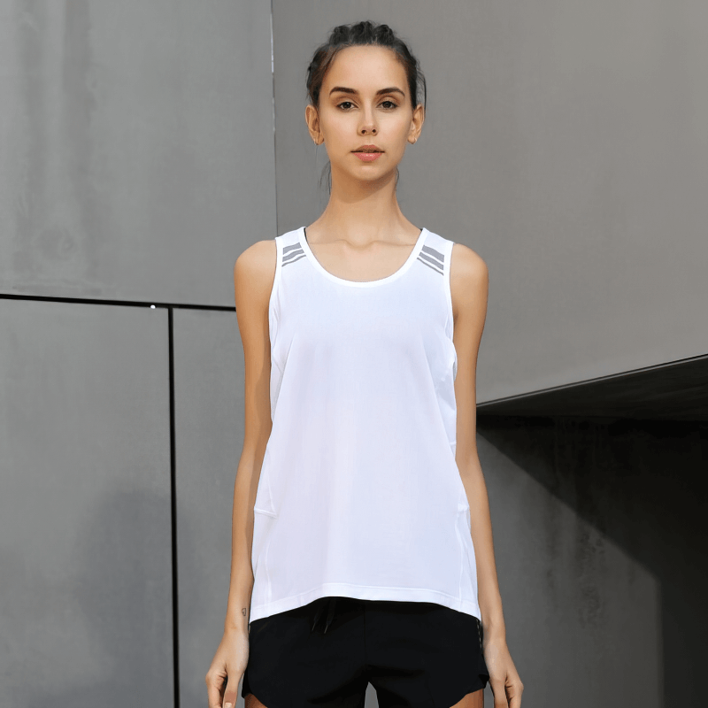 Woman wearing white solid color loose tank top, perfect for running and sports activities, showing breathable and stylish design.