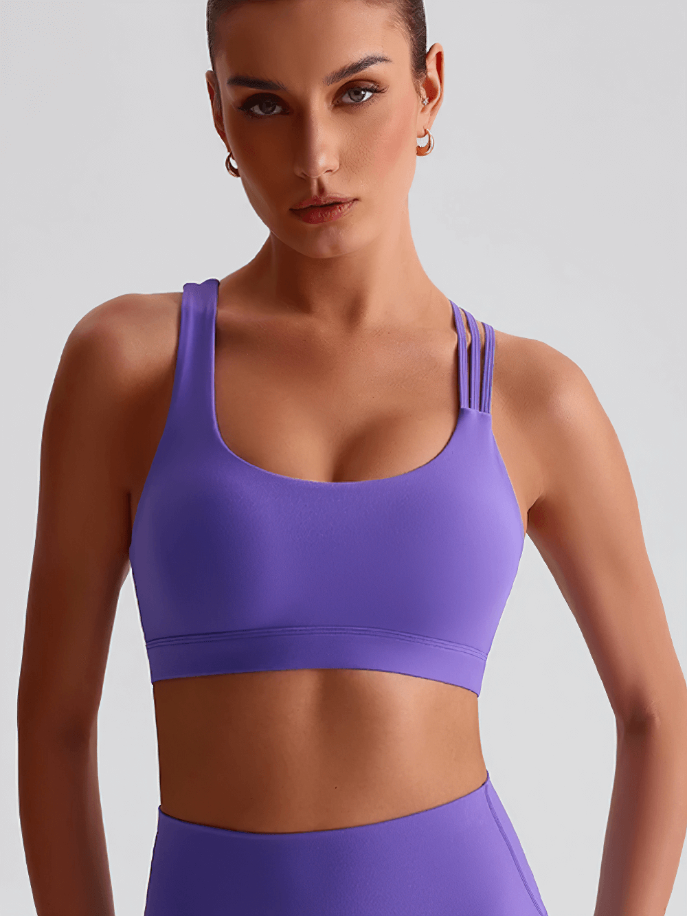 Woman wearing a Solid Color Sports Bra with Criss-Cross Back - SF4060 in vibrant purple, showcasing stylish X-Back design for active wear.
