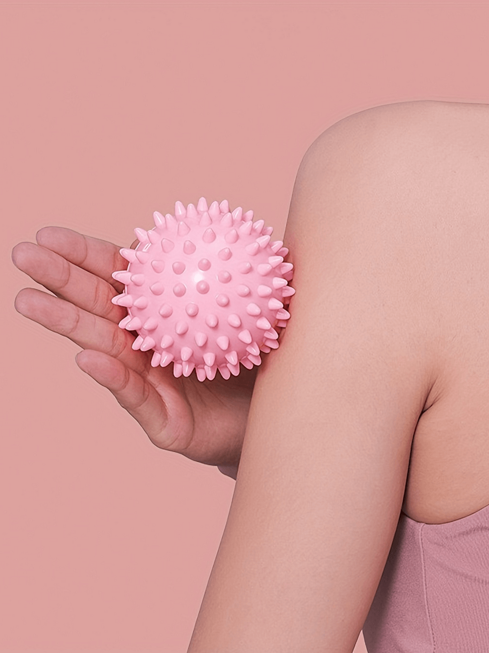 Alt Tag: Person using pink spiky massage ball for neck and shoulder muscle relaxation, ideal for yoga and fitness recovery.