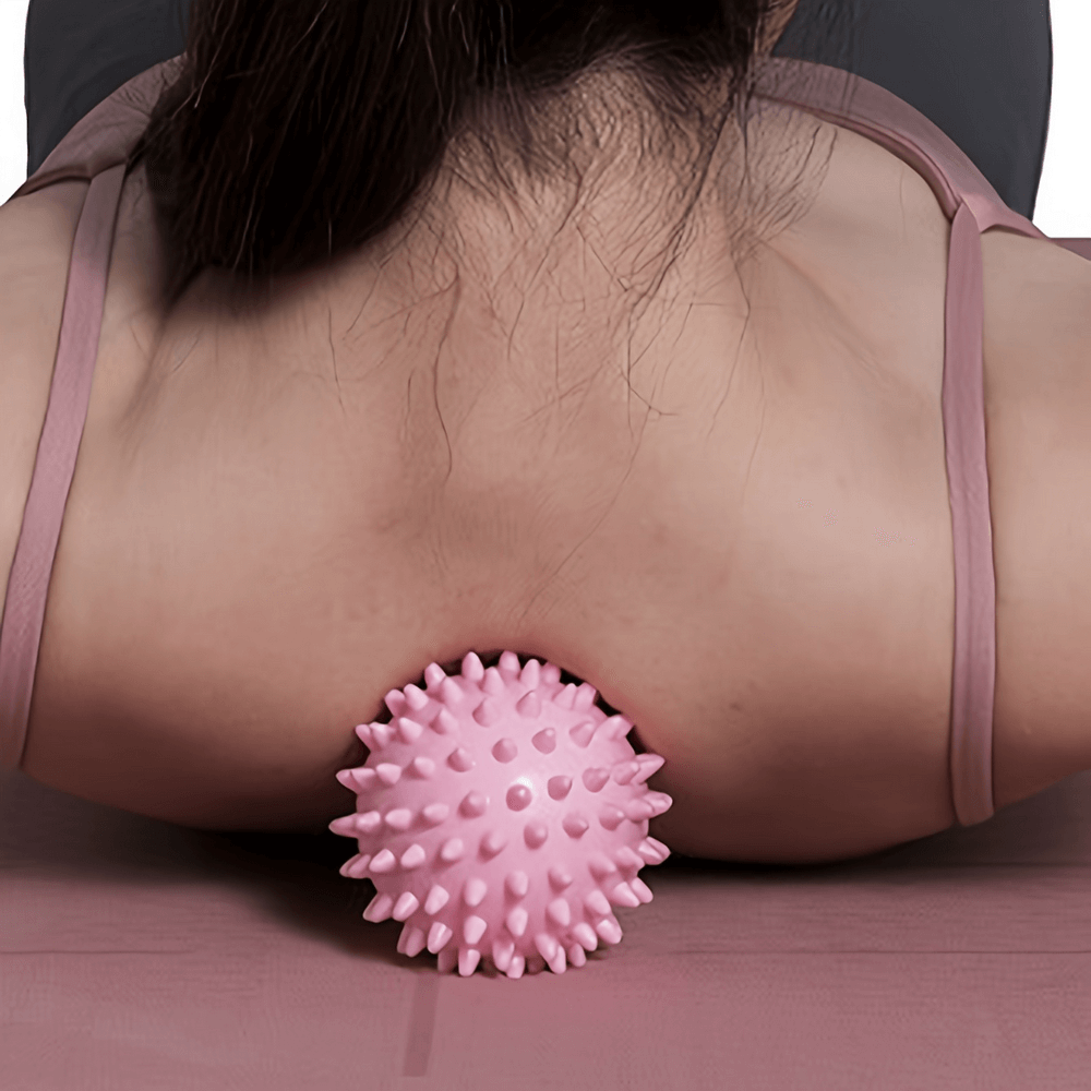 Woman using pink spiky massage ball SF2836 on back for deep tissue relaxation and muscle relief, perfect for yoga and fitness recovery.