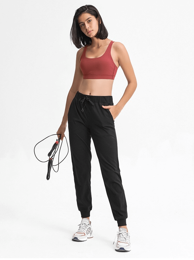 Woman wearing Sports Breathable Loose Women's Training Pants SF1420, holding a jump rope, ready for workout.