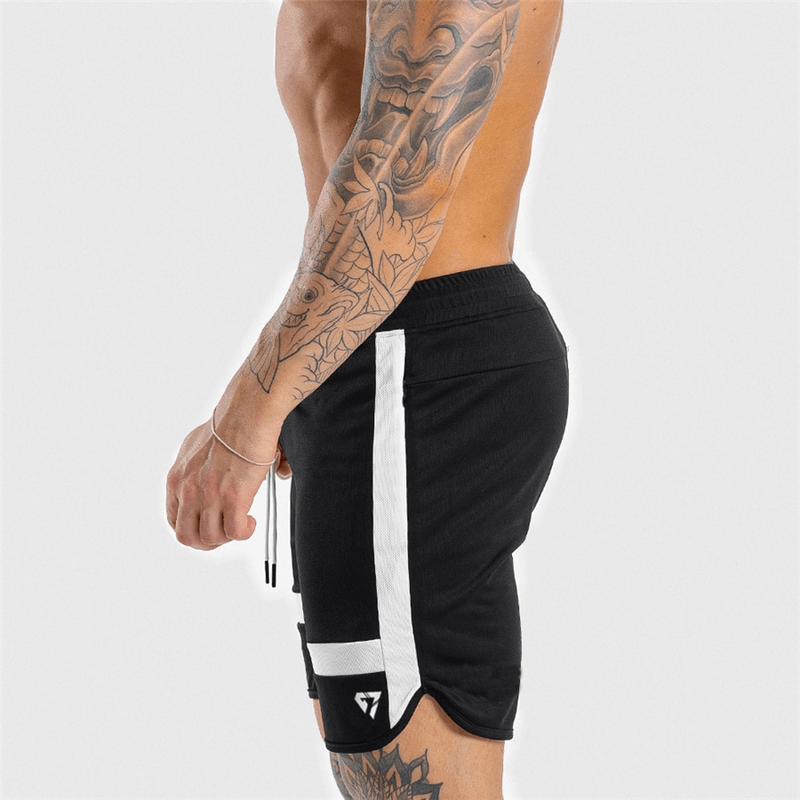 Side view of a man wearing black sports elastic shorts with white patchwork, ideal for workouts, featuring a secure drawstring fit.