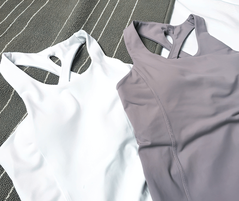White and lavender sports elastic tight women's cross-back yoga tank tops on display