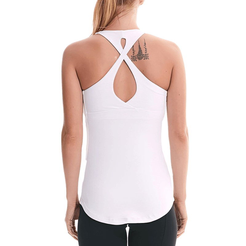 Woman wearing white cross-back yoga tank top, ideal for sports and workouts.