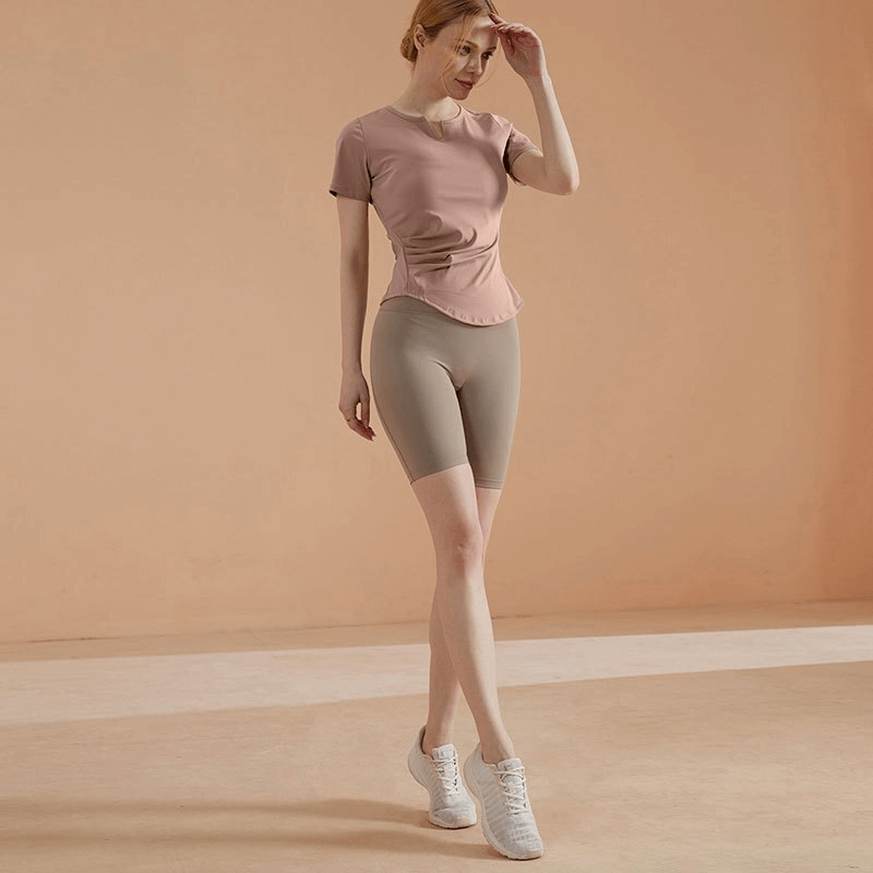 Woman wearing sports elastic fitness shorts with high waist, standing in a workout pose, showcasing comfort and mobility.