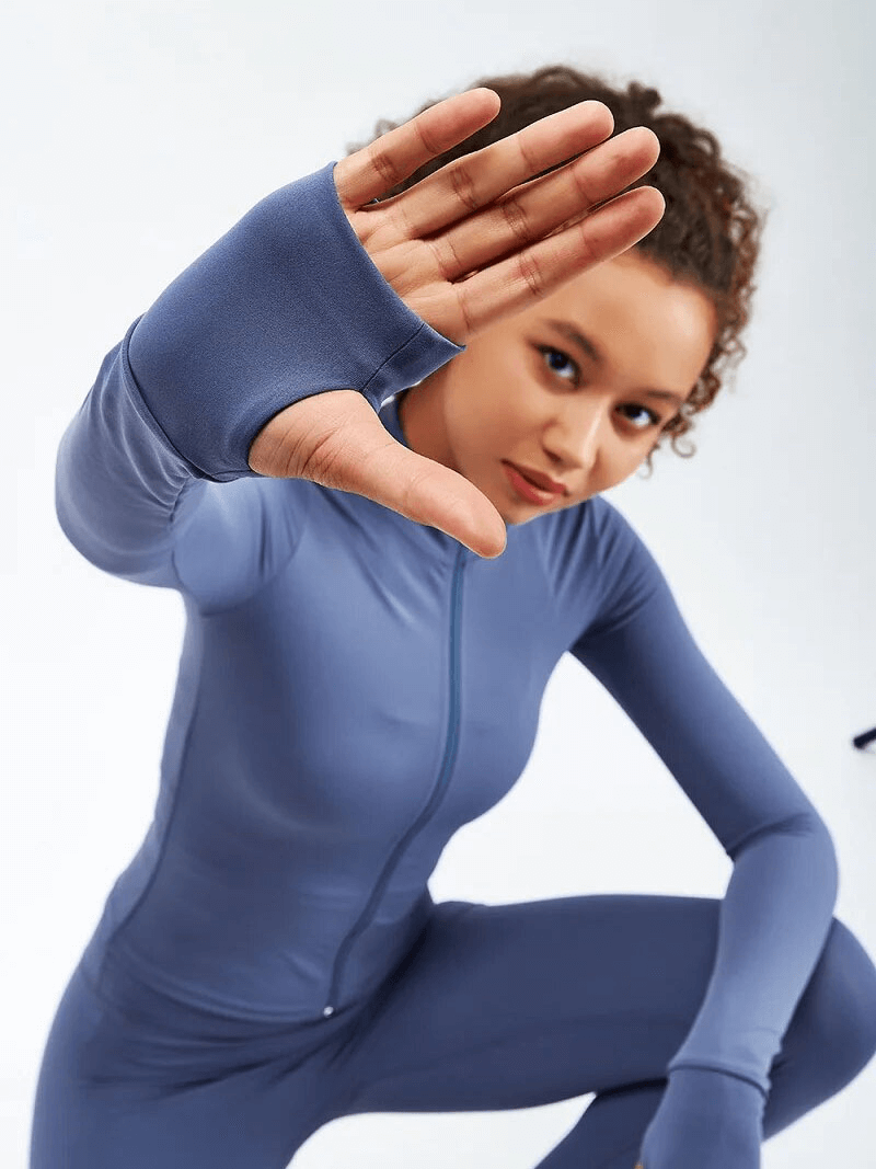 Woman in a blue full-sleeve sports fitness outfit striking a dynamic pose, highlighting the stylish and breathable design, perfect for workouts.