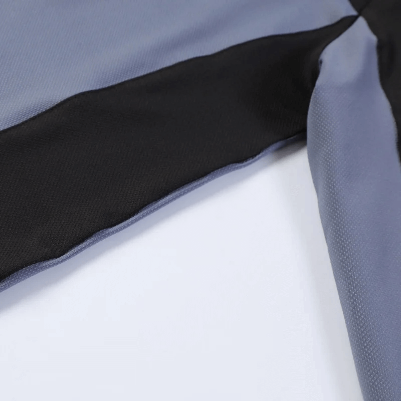 Close-up of blue and black men's half-zip long sleeve running top fabric, showcasing breathable material and design details