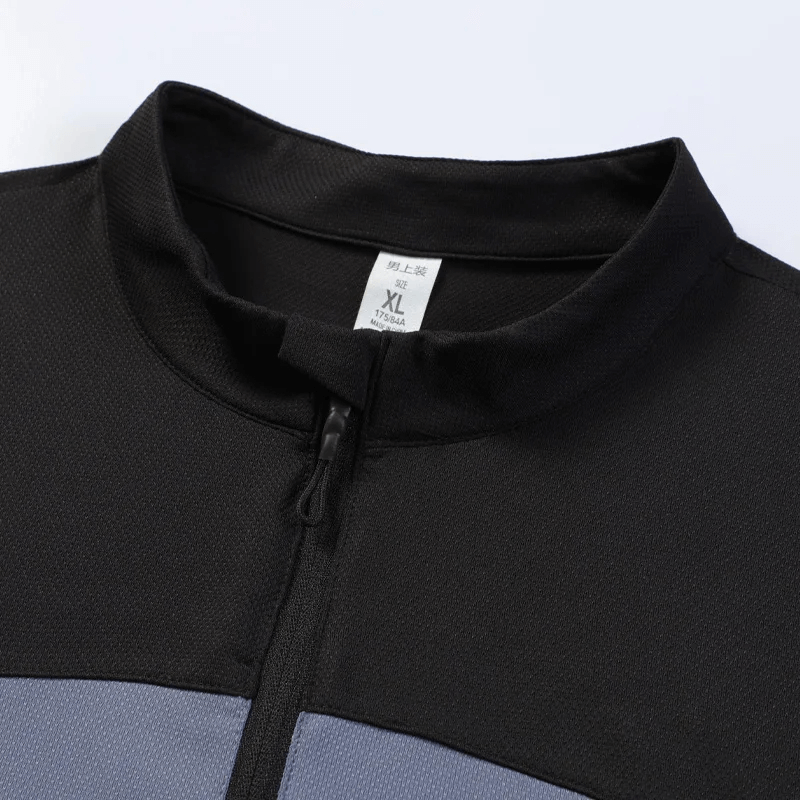 Close-up of a men's black and blue half-zip long sleeve sports shirt, featuring a breathable fabric for comfort during workouts.
