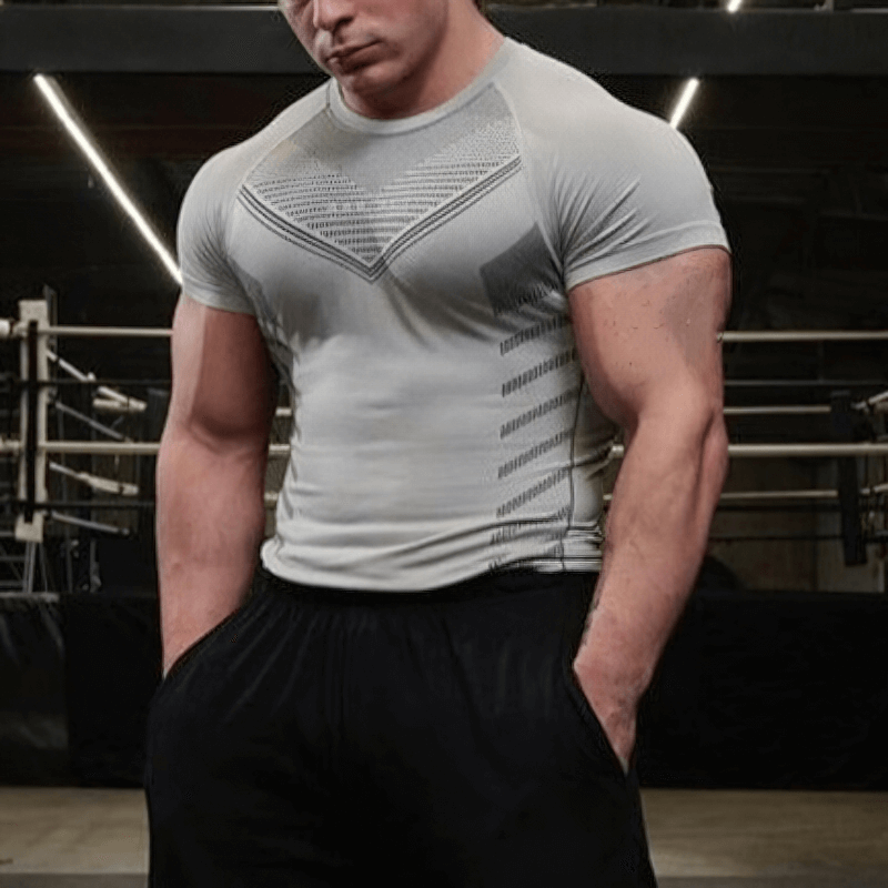 Man wearing a gray athletic quick-dry t-shirt with short sleeves, perfect for workouts. O-neck design in a gym setting.