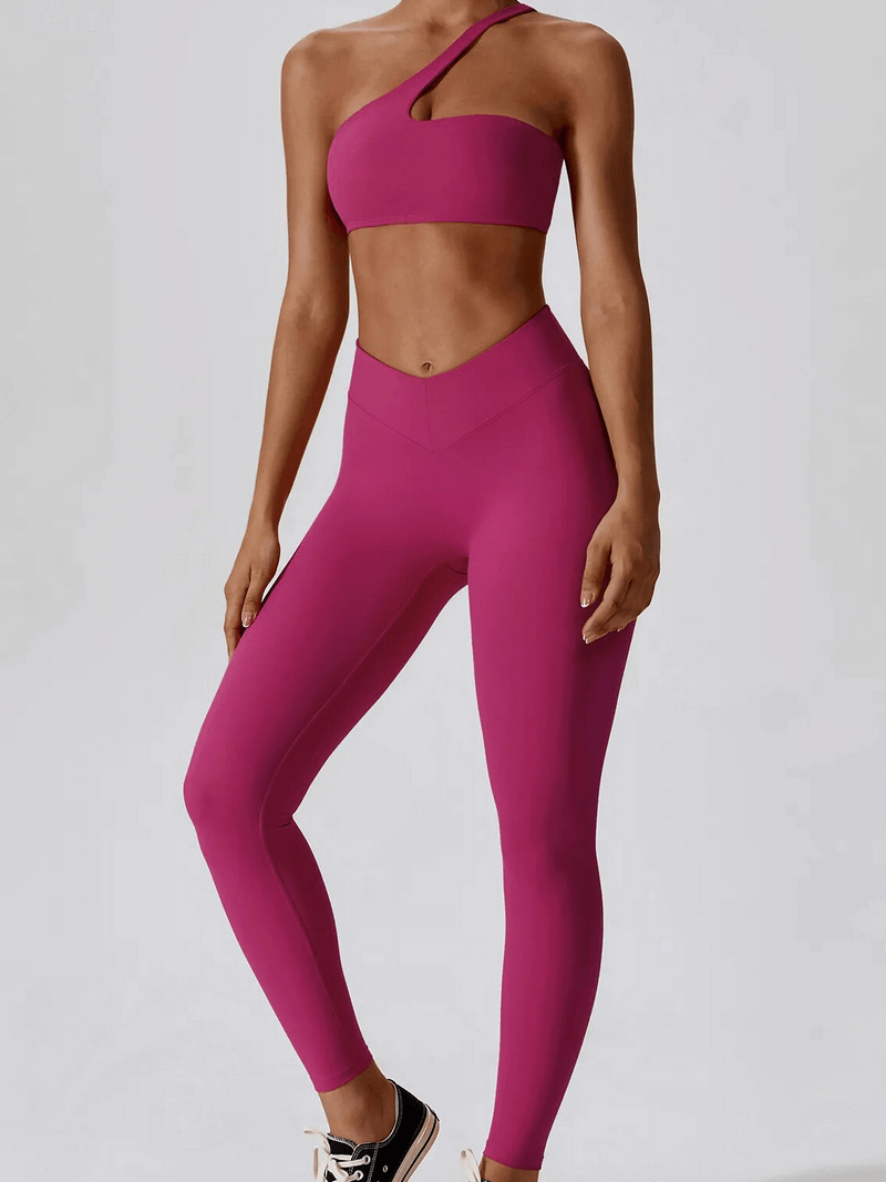 Woman wearing pink sports one shoulder push-up bra and leggings set, perfect for exercise and style.