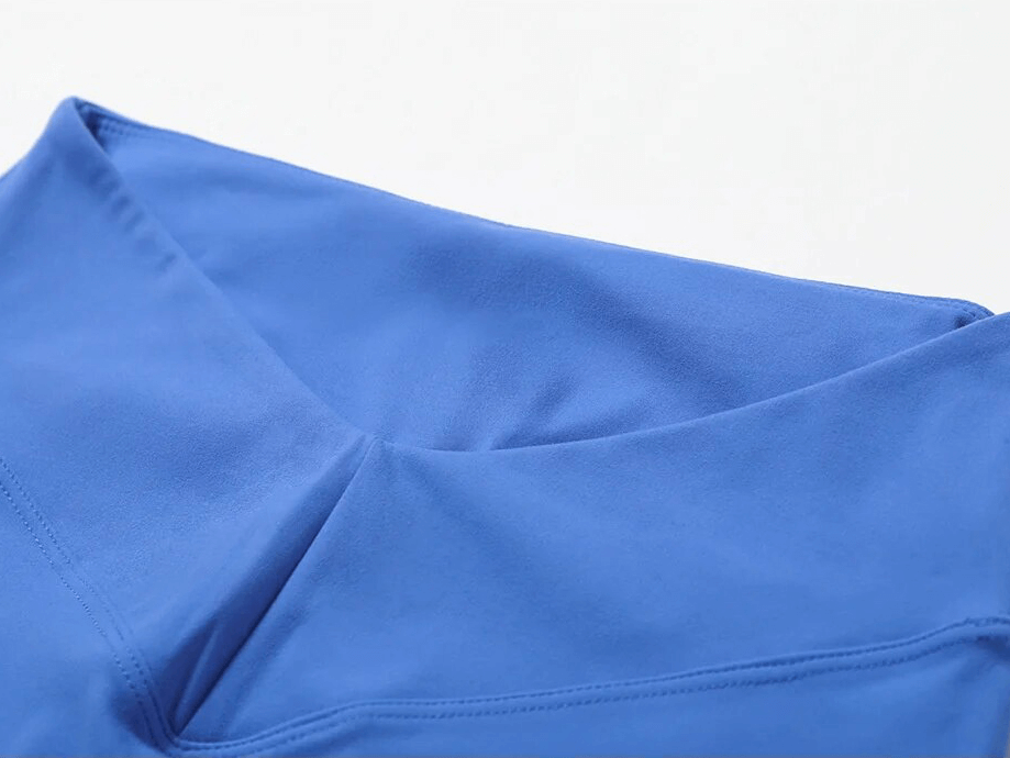 Close-up of blue sports leggings, highlighting soft nylon fabric and seamless stitching for comfort and style during workouts.