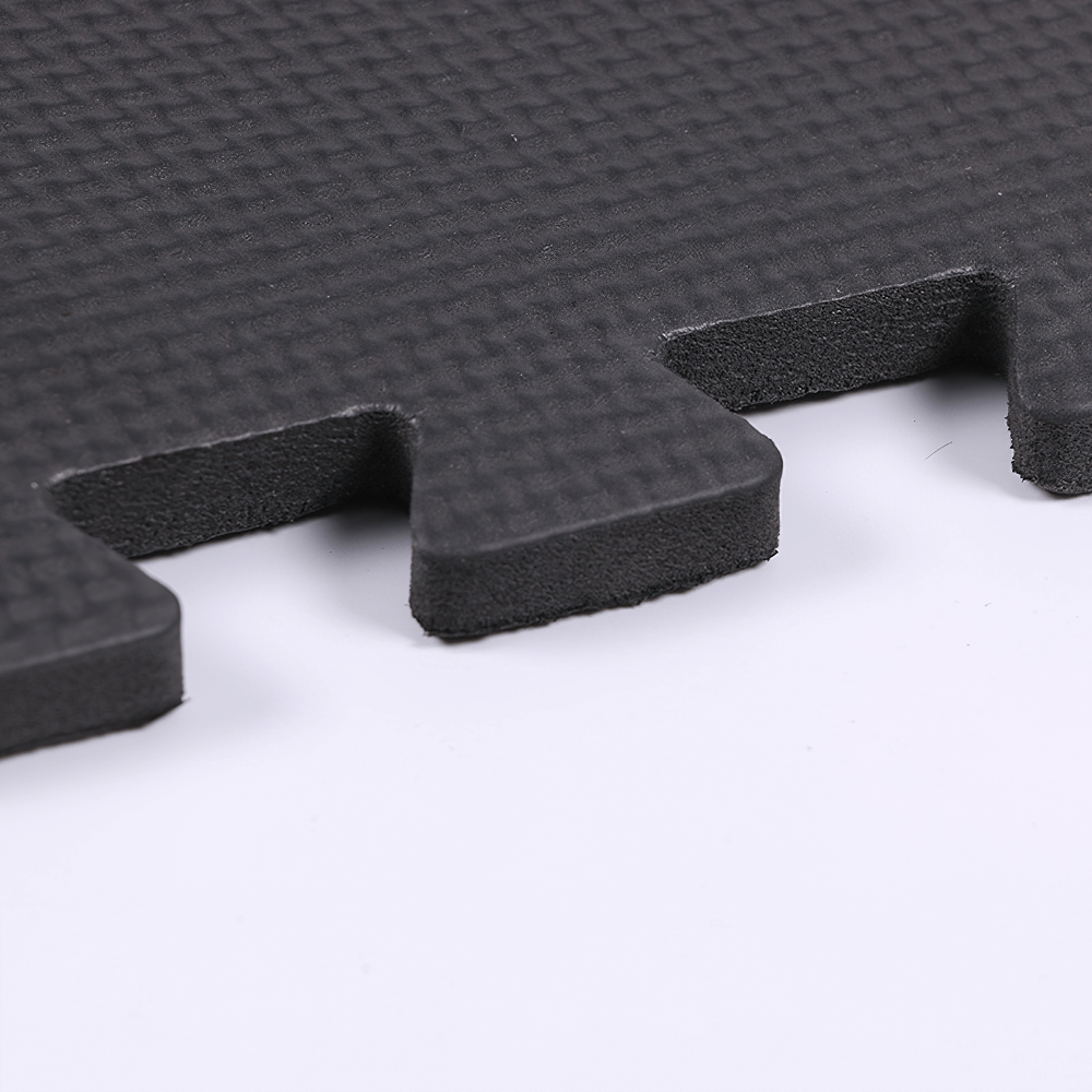 Close-up view of a black cross-pattern non-slip gym mat. Perfect for stability in yoga and fitness activities. Durable and protective.
