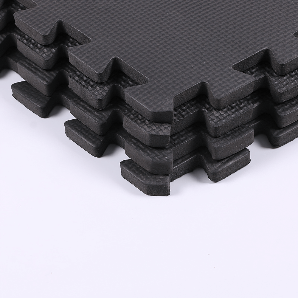 Stack of black cross-pattern EVA floor gym mats for stability and non-slip protection, ideal for workouts and yoga.