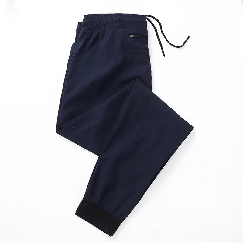Sports quick-drying men's pants with zippered pockets, ideal for running, featuring breathable nylon/polyester blend and elastic waist.
