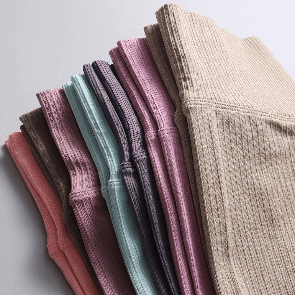 Colorful stack of ribbed high waist leggings for women, featuring seamless design and elastic waistband. Ideal for yoga and exercise.