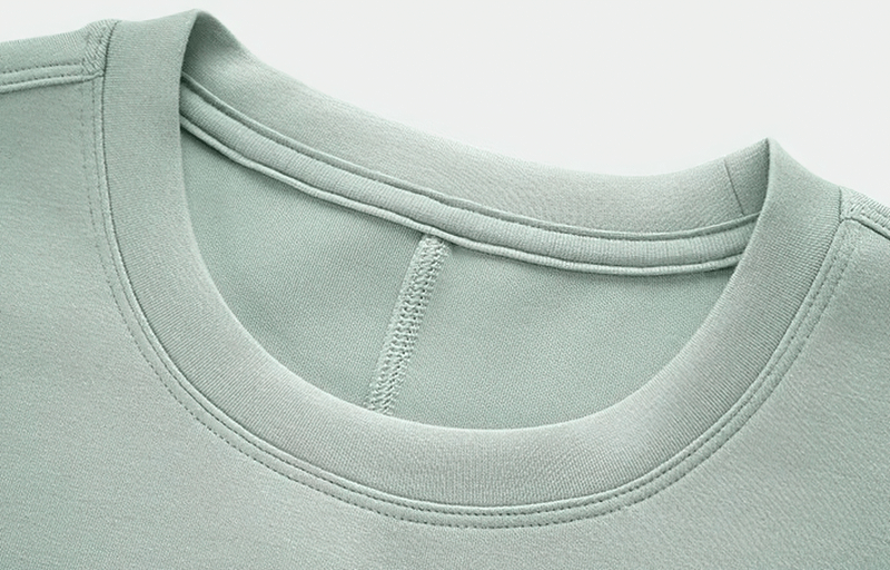 Close-up of a mint green sports crop T-shirt with short sleeves and adjustable hem, made of lycra, nylon, and spandex.