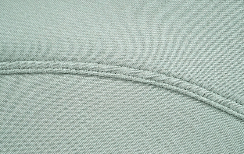 Close-up of the textured seam on a mint green sports crop T-shirt, highlighting its durable fabric and quality stitching.