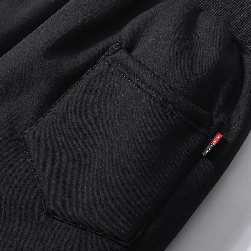 Close-up of black sports warm fleece men's pants pocket with ribbed waistband