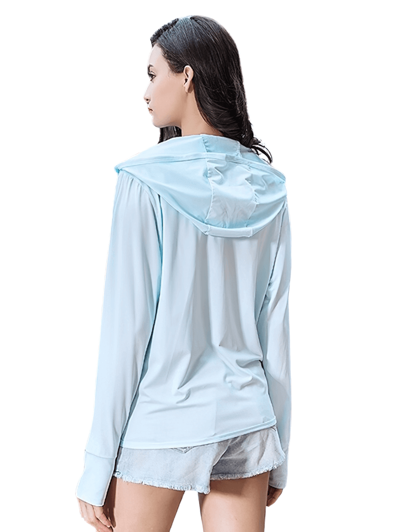 Woman wearing light blue sports windbreaker for trekking, showcasing breathable waterproof design and hood for outdoor activities.