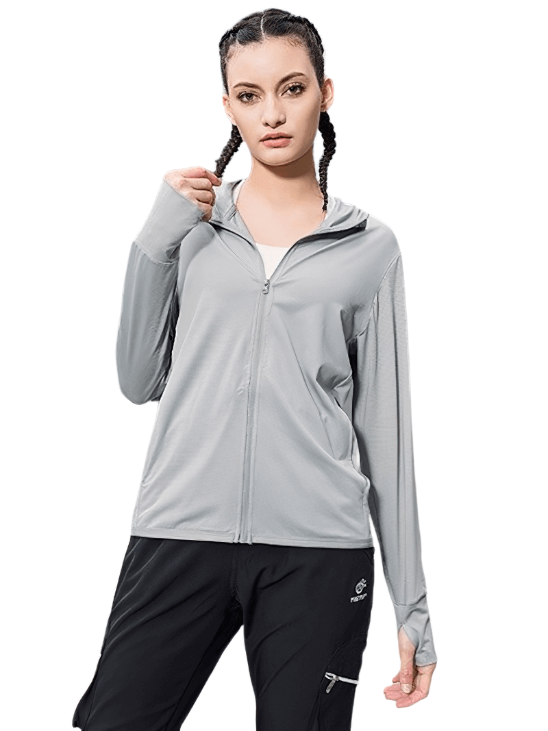 Woman wearing a gray waterproof windbreaker ideal for trekking, made of breathable, quick-dry polyester and spandex for outdoor adventures.