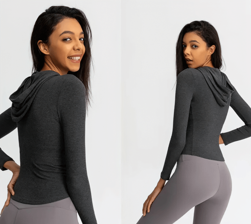 Back view of a woman wearing a gray sports zipper jacket with long sleeves and hood, showcasing its fit and style.