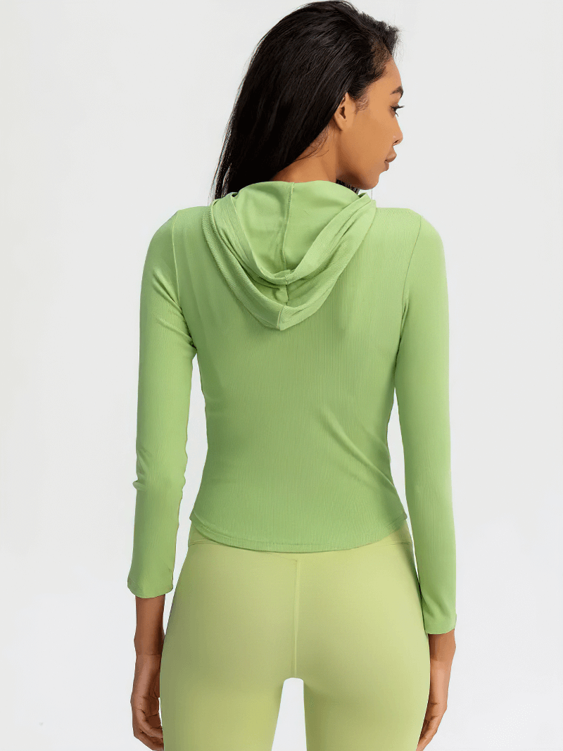 Back view of woman wearing a green sports zipper jacket with hood and long sleeves, designed for comfort and outdoor activities.